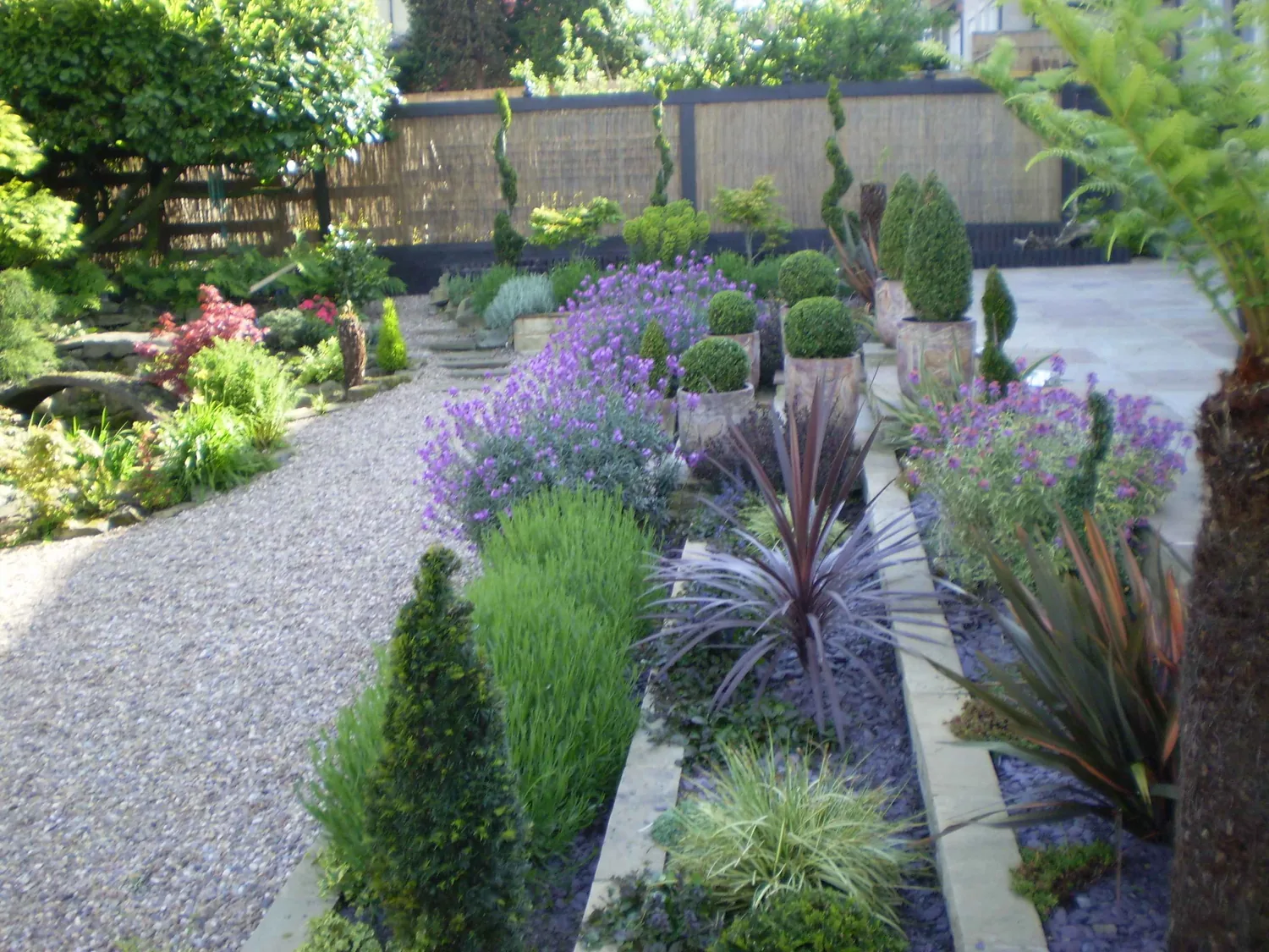 Formal garden with layered planting and gravel path